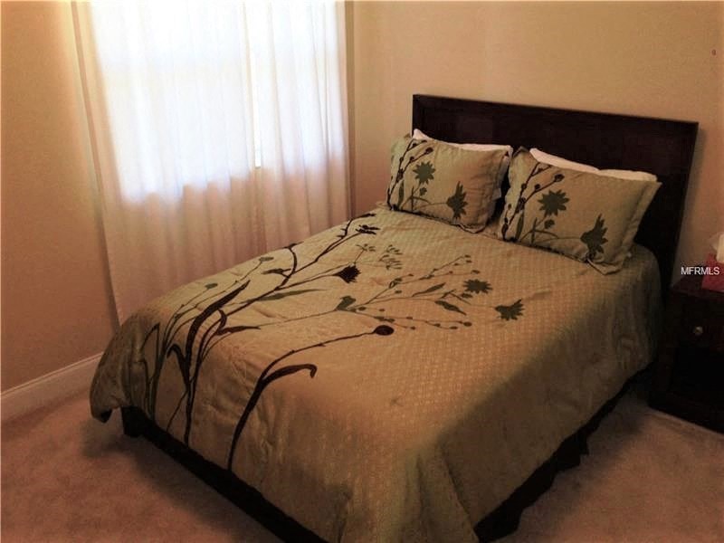 a bed with two pillows on it in a bedroom