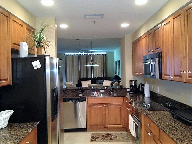 a kitchen with granite counter tops and a stainless steel refrigerator