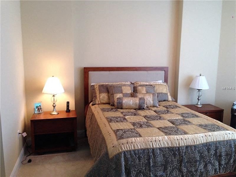 a bedroom with a bed and two lamps