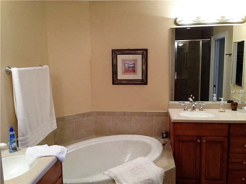 a bathroom with a tub and a sink and a mirror