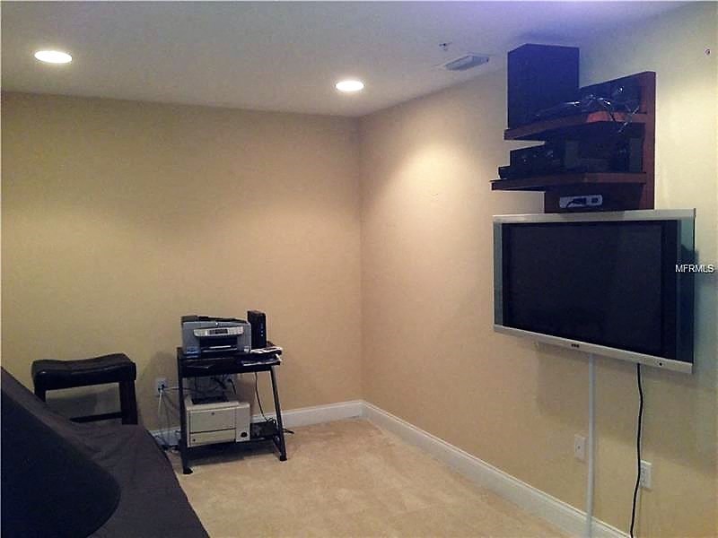 a living room with a tv and a table with a chair