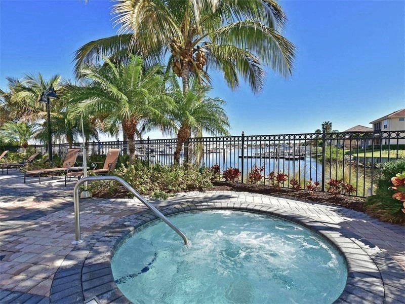 a hot tub with palm trees next to a body of water