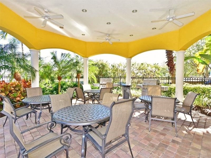 a covered patio with tables and chairs