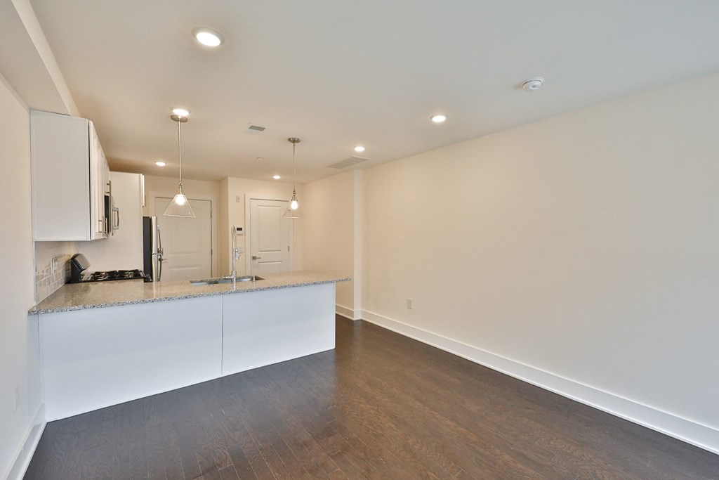 a kitchen with white cabinets and a counter top in a living room