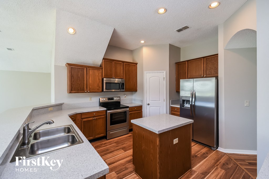 a kitchen with wooden cabinets and stainless steel appliances