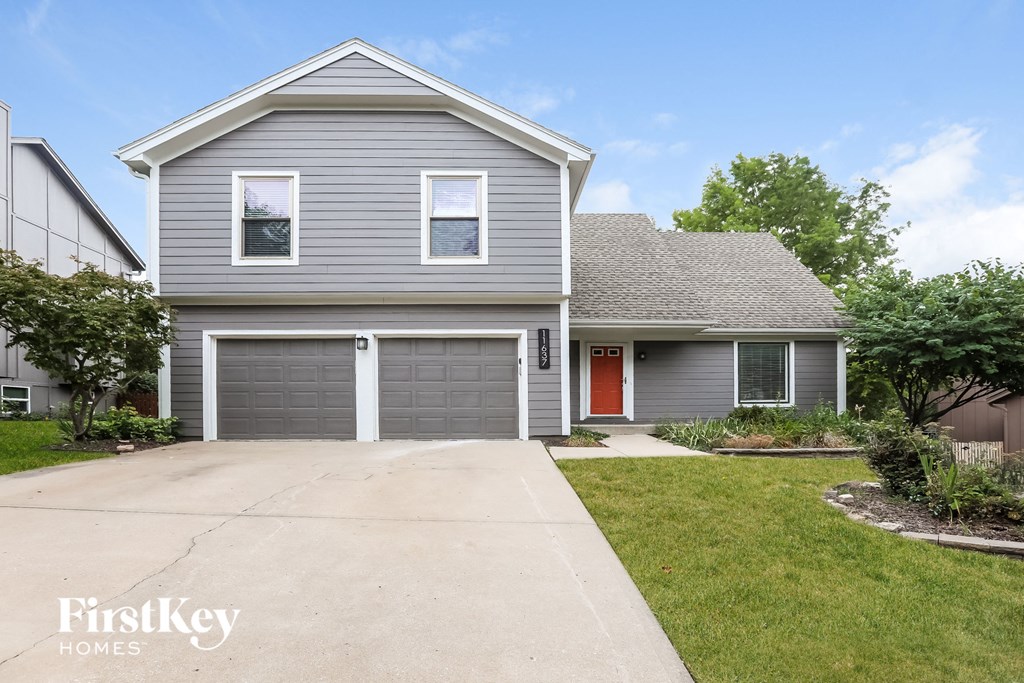 a blue house with a driveway and a garage door