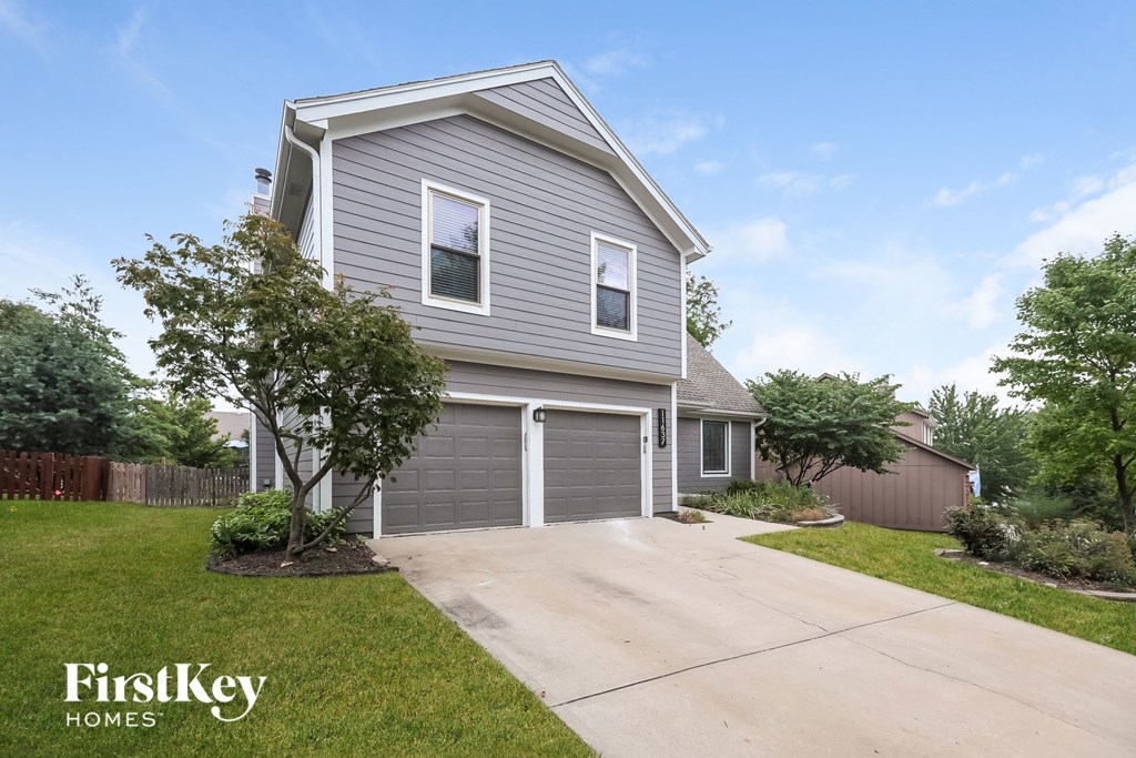 a gray house with a driveway and a garage door