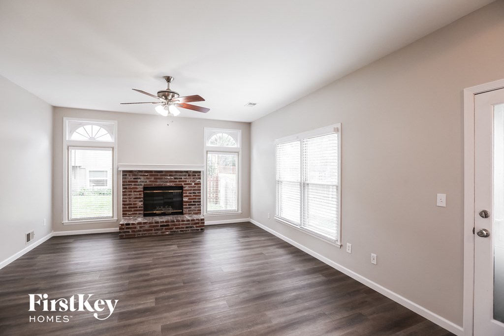 a living room with a fireplace and a ceiling fan
