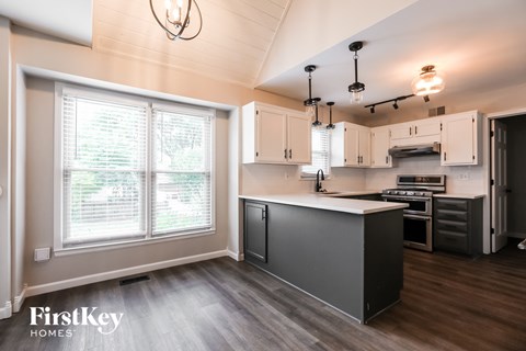 a kitchen with white and black cabinets and a large window