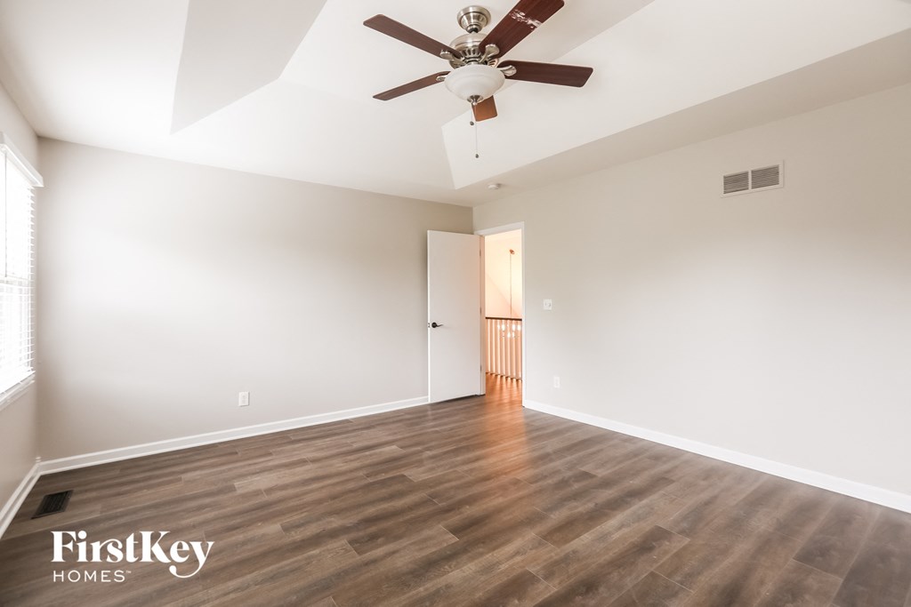 a living room with a ceiling fan and wood floors