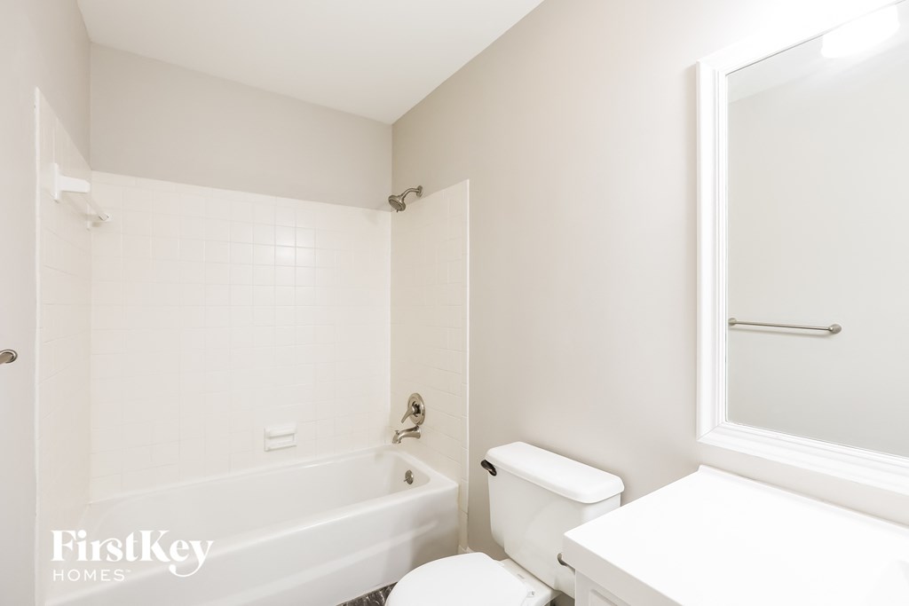 a white bathroom with a tub and a toilet and a sink