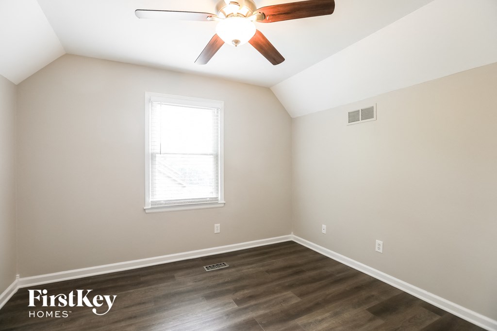 an empty room with a ceiling fan and a window