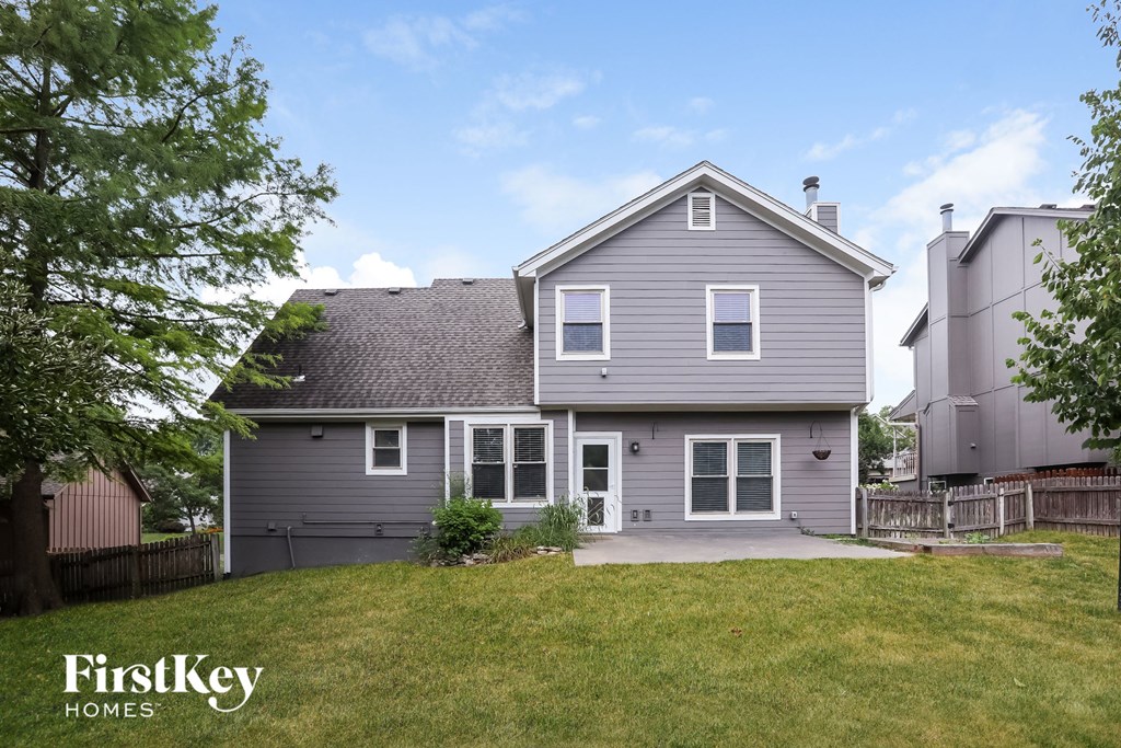 a gray house with a yard and a driveway