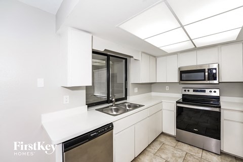 A kitchen with a stainless steel dishwasher and oven.