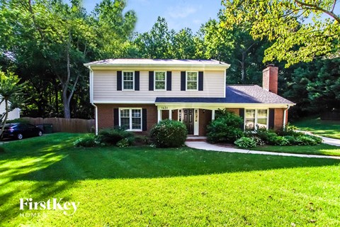 a white house with a lawn and a driveway