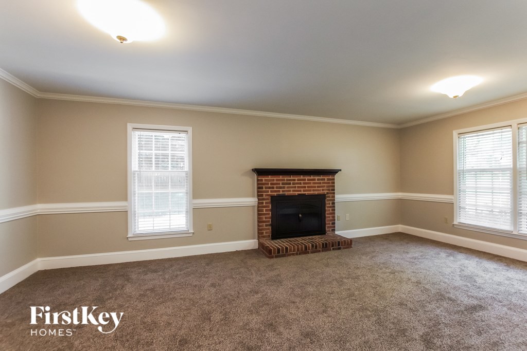 a living room with a fireplace and a carpeted floor