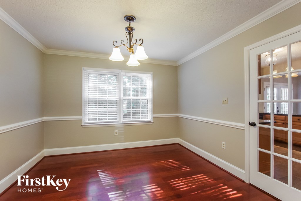 an empty dining room with a window and a door to a closet