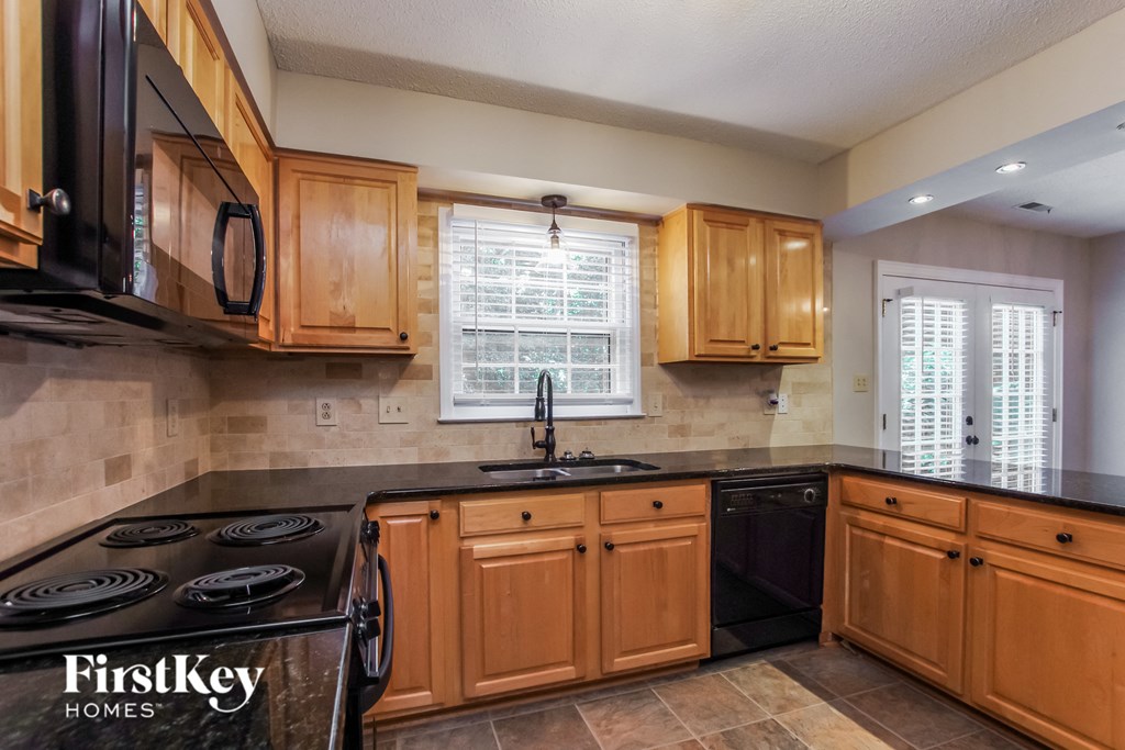 a kitchen with wooden cabinets and black appliances