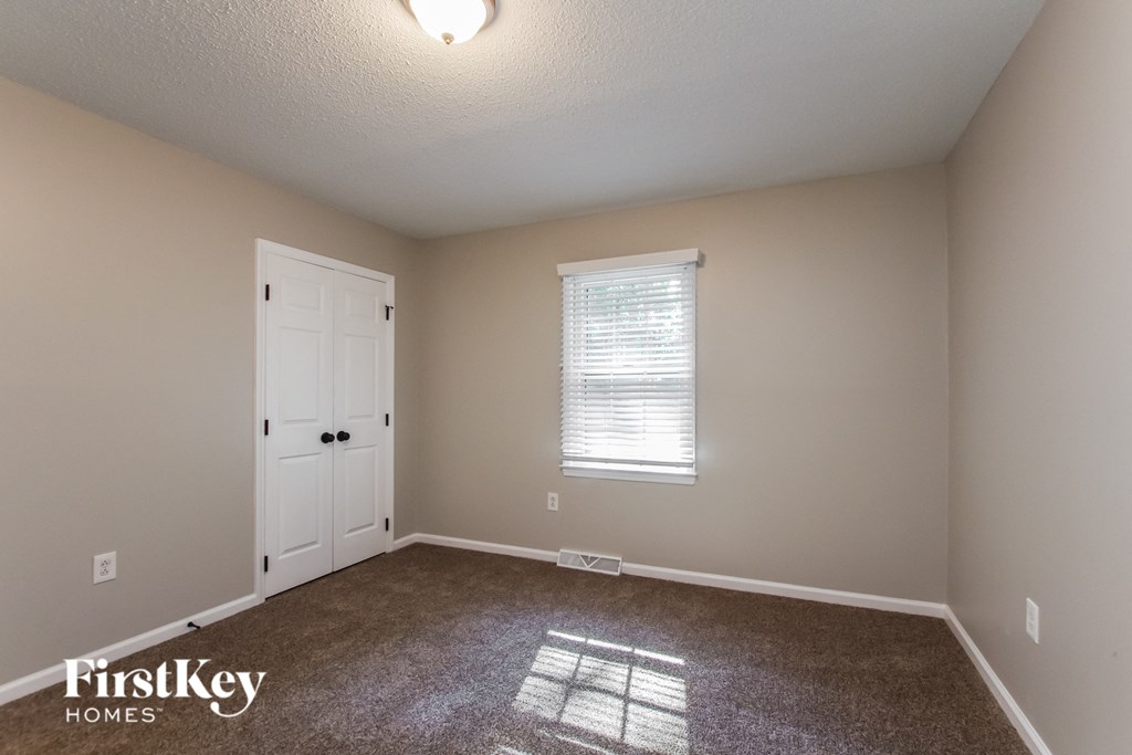 a bedroom with a carpeted floor and a white door