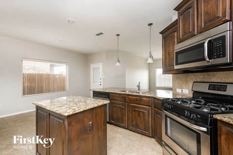 a kitchen with wooden cabinets and stainless steel appliances and granite counter tops