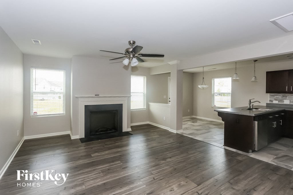 a living room with a fireplace and a kitchen
