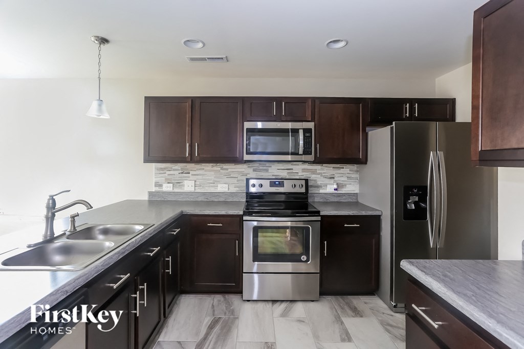 an updated kitchen with stainless steel appliances and wooden cabinets