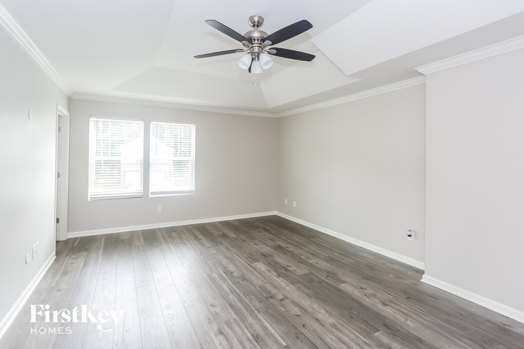 a living room with wood floors and a ceiling fan