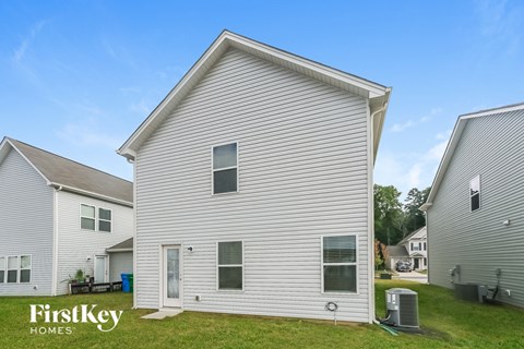 a white house with white siding and a grassy yard