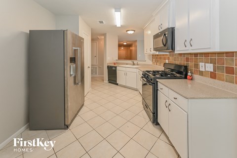 a kitchen with white cabinets and a stainless steel refrigerator