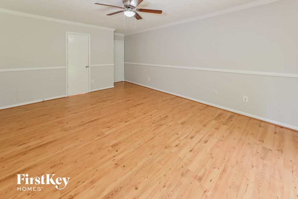the living room with wood flooring and a ceiling fan