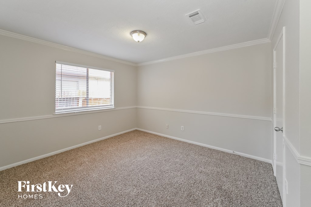 a bedroom with a carpeted floor and a window