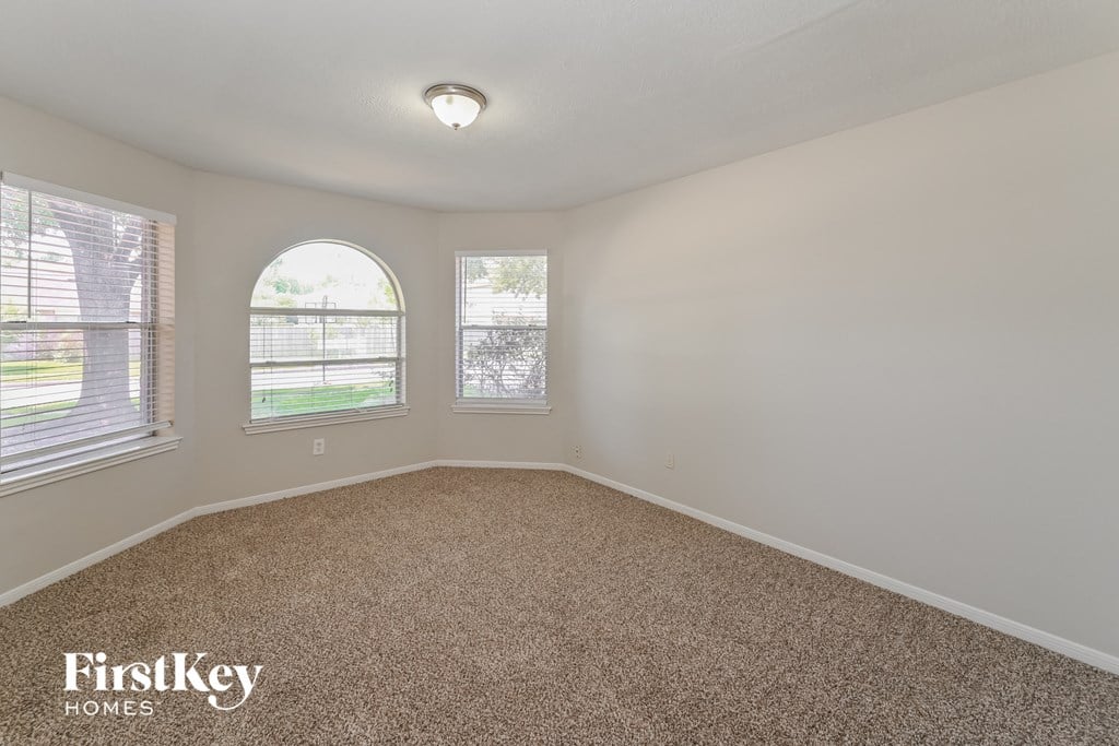 a bedroom with a carpeted floor and two windows