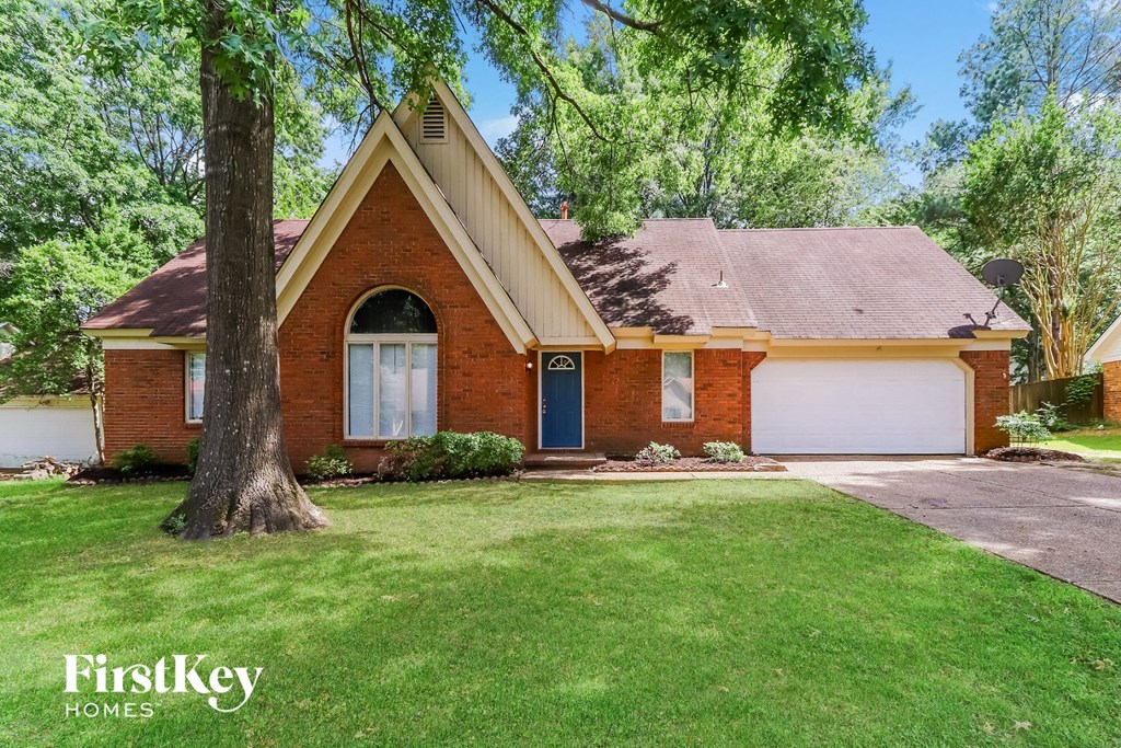 A brick house with a blue door and a garage door.