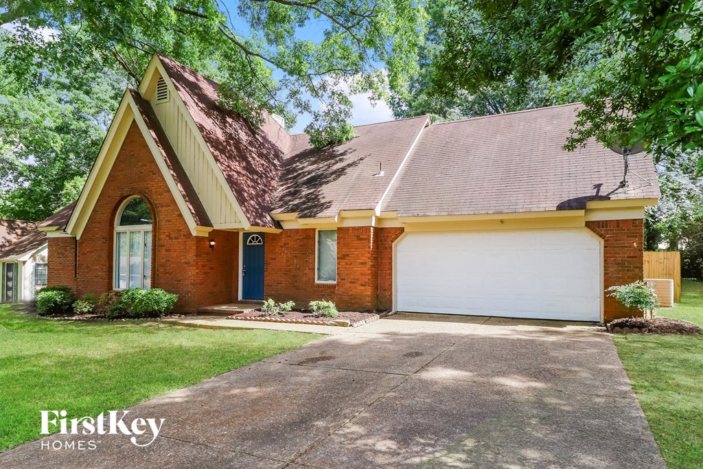 A brick house with a garage door is for sale.
