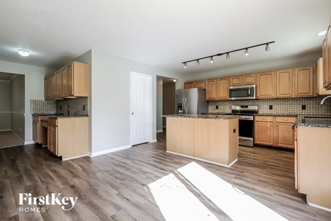 A kitchen and living room are shown in a model home.
