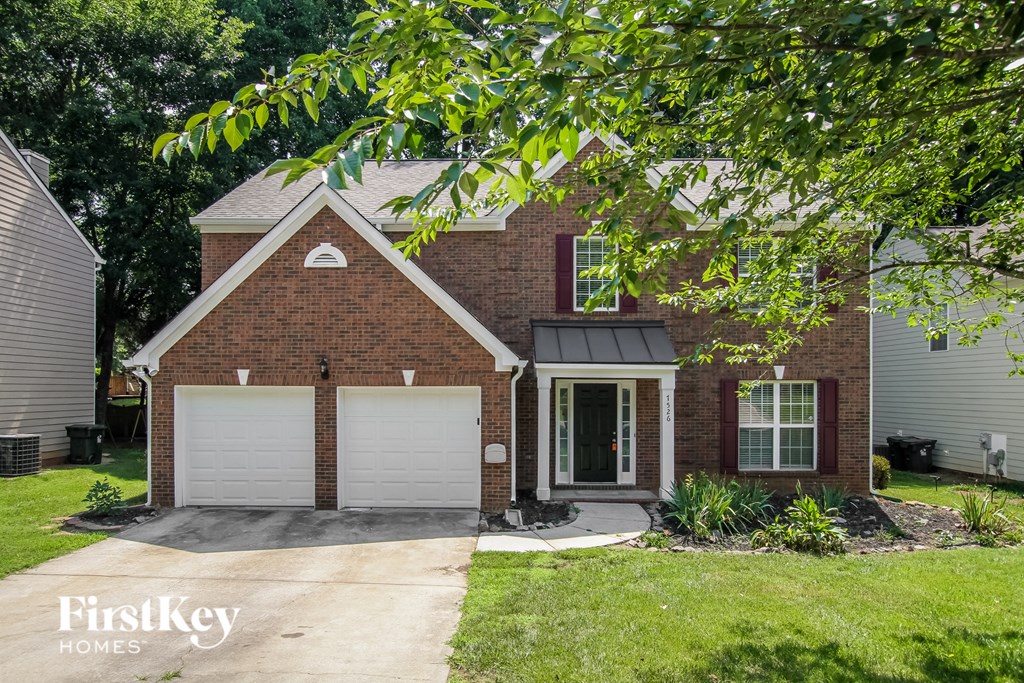 a small brick house with a white garage door