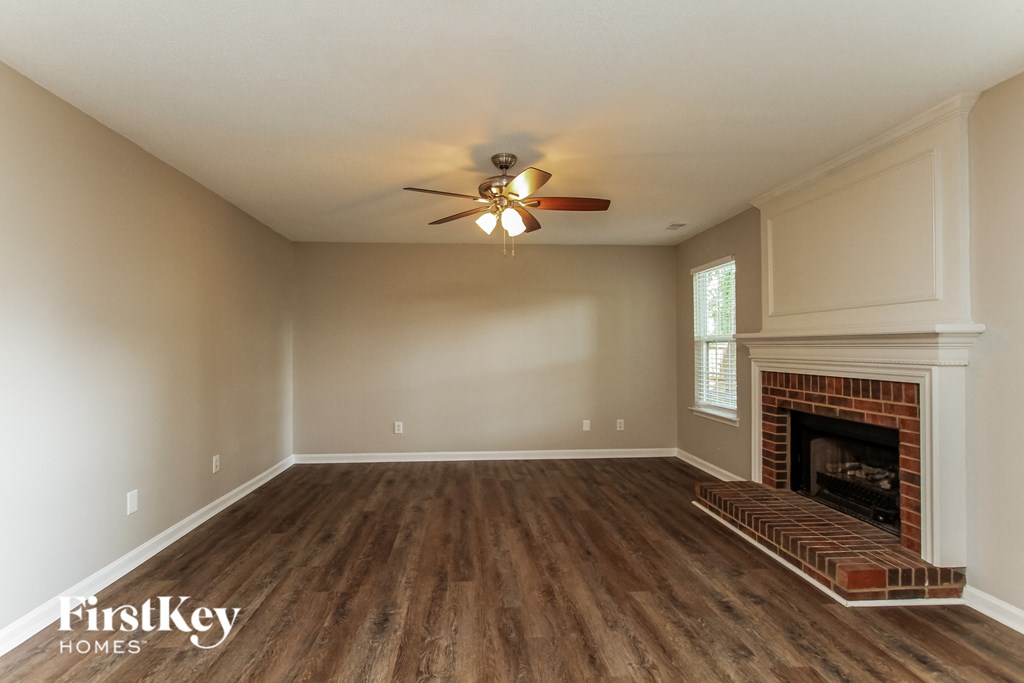 a living room with a fireplace and a ceiling fan