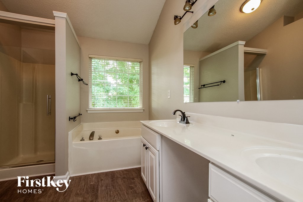 a bathroom with a tub and a sink and a mirror