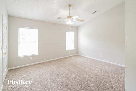 a bedroom with carpet and a ceiling fan