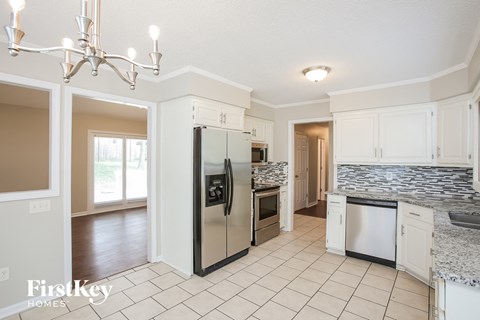 A kitchen with a refrigerator, dishwasher, and oven.