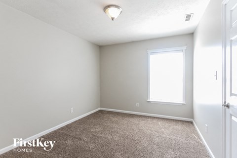 a bedroom with a carpeted floor and a window