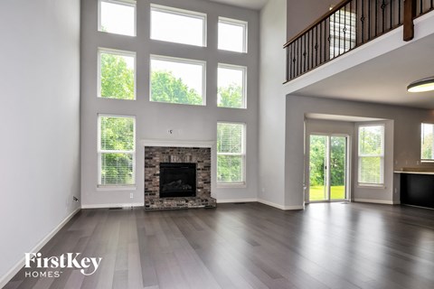 a living room with large windows and a fireplace