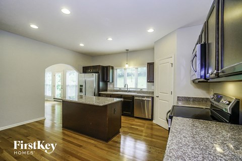 a kitchen with an island and a refrigerator and a sink