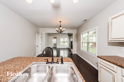 A kitchen with a sink and a chandelier.