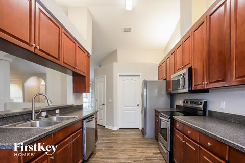 A kitchen with brown cabinets and a stainless steel refrigerator.