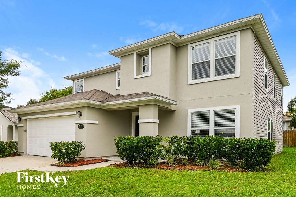a beige house with a lawn in front of it