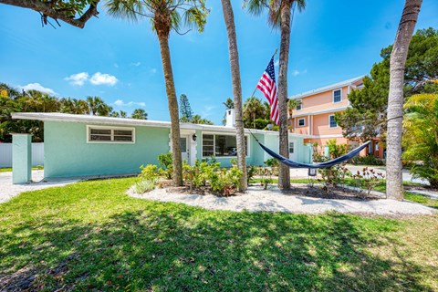 A house with a hammock between two trees.