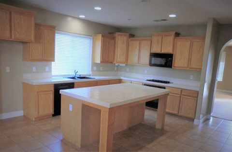 an empty kitchen with wooden cabinets and a counter top