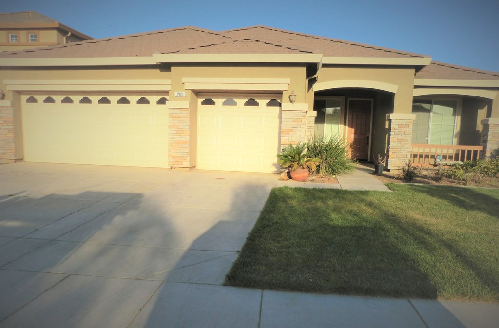 a driveway in front of a house with a garage door