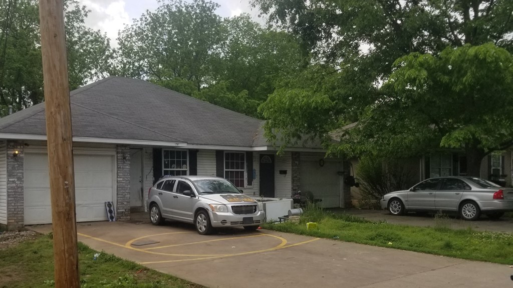 a house with two cars parked in front of it
